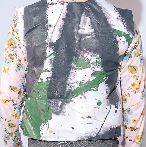 Person wearing a colorful, patterned shirt with a plain background