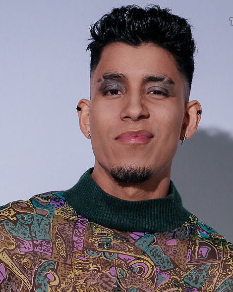 Man wearing a patterned shirt with a plain background