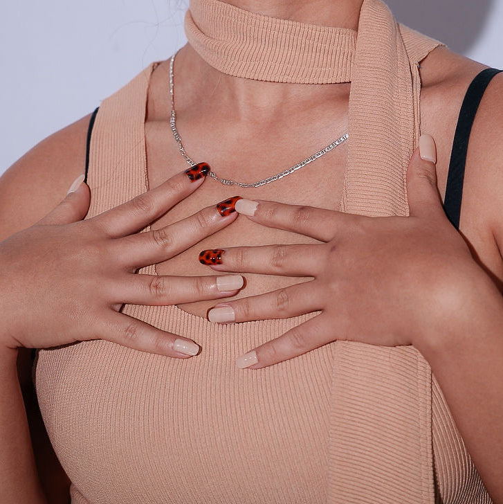 Woman wearing a beige top with a plain background