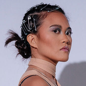 Woman wearing a beige top and pink skirt against a white background