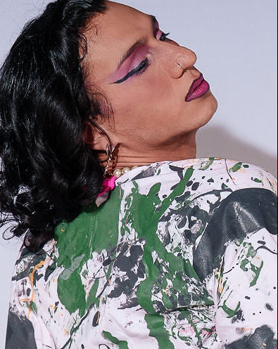 Person wearing a colorful, abstract-patterned outfit against a plain background