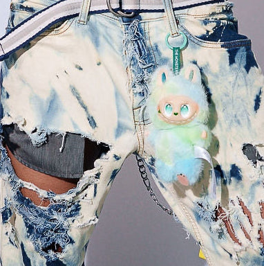 Man wearing a floral shirt and colorful pants against a plain background