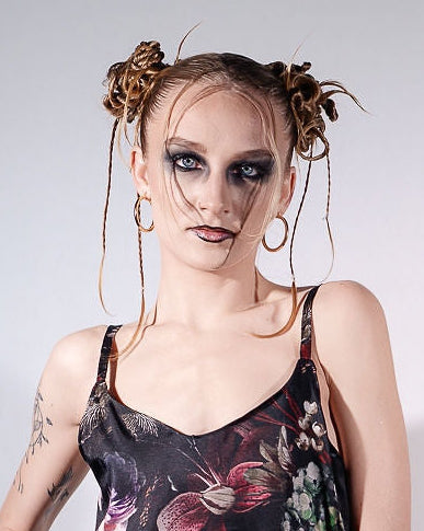 Woman wearing a floral slip dress against a plain background